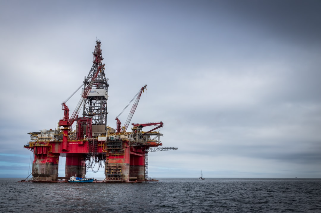 red and grey oil platform in sea
