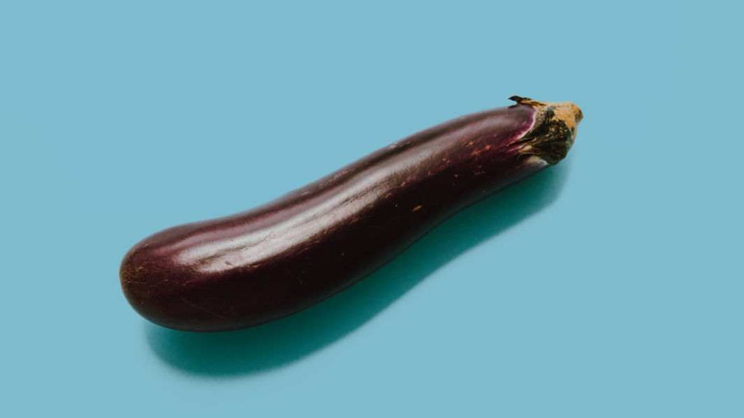 brown eggplant on teal surface